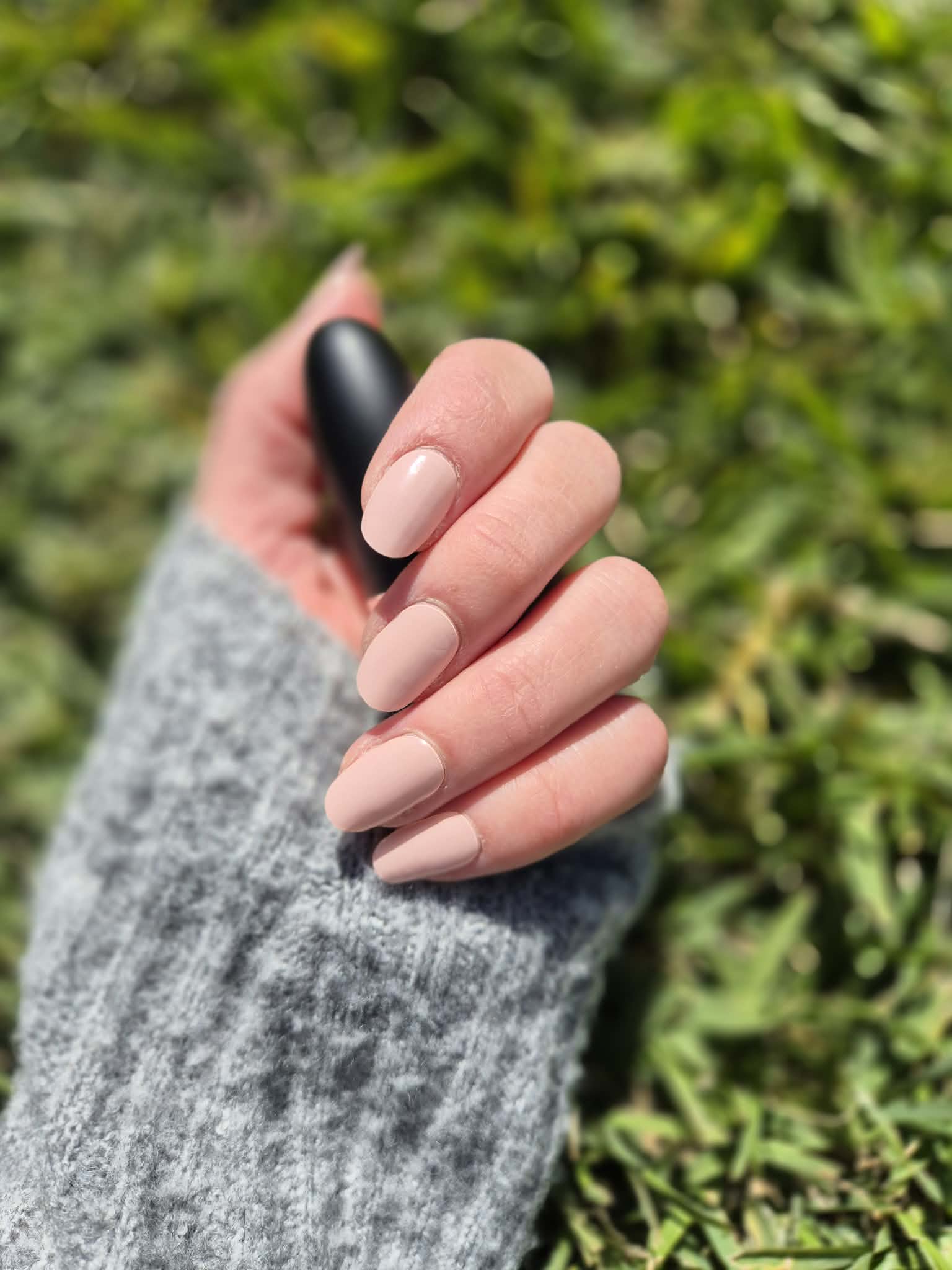 Close-up of glossy semi-cured gel nails in natural lighting