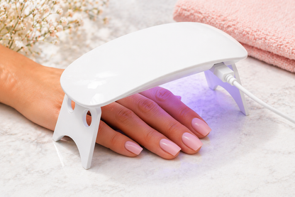 Hand curing gel nail stickers under UV lamp for salon-style nails at home